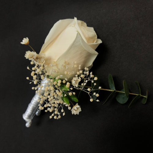 Single perfect white rose with small amount of foliage to create a stunning boutonniere 