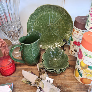 Green ceramic tableware. Large green jug and medium plate and medium green bowls. 