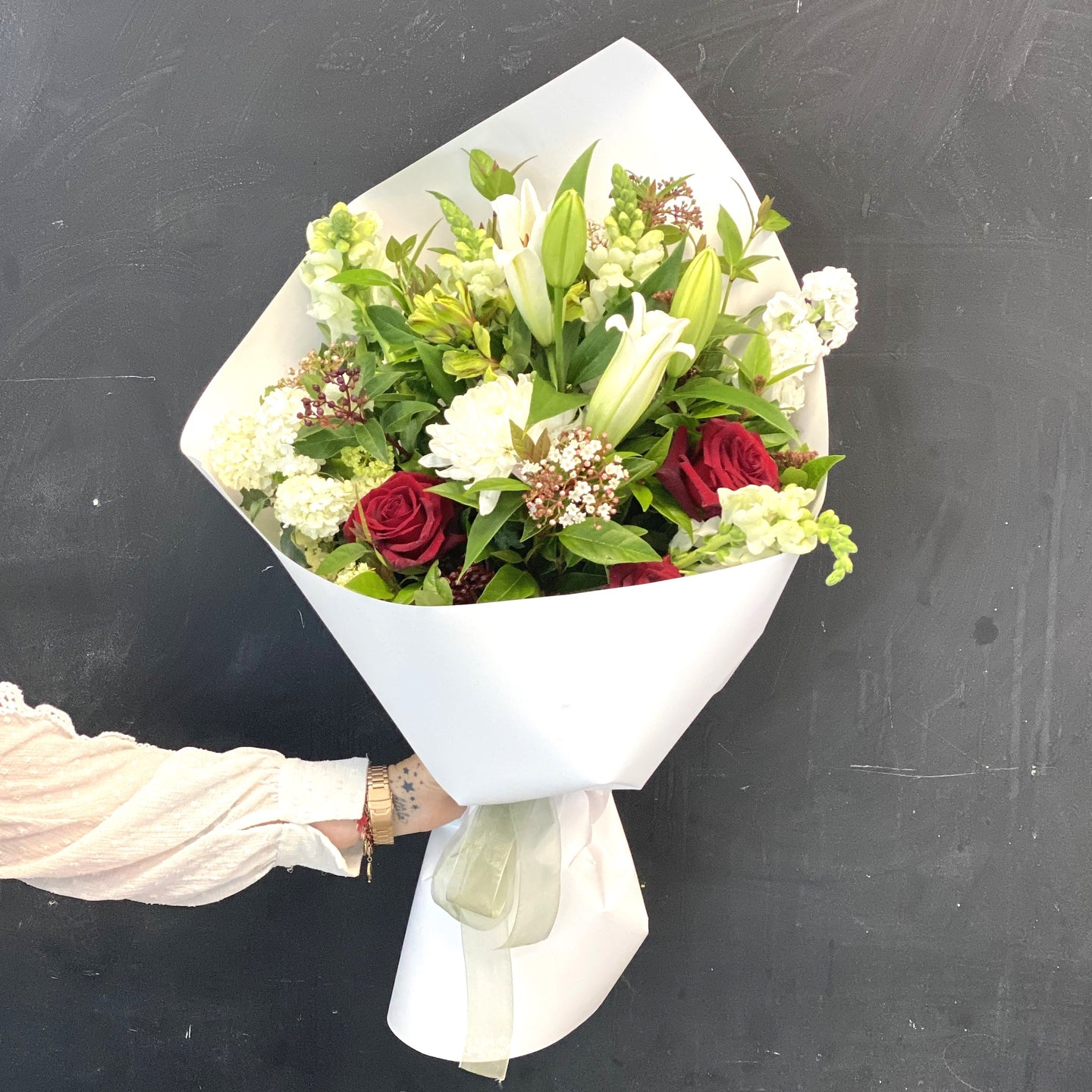 Blanc Flowers Christmas theme bouquet featuring seasonal red white and green blooms and foliage.