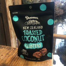 Load image into Gallery viewer, At Blanc Flowers we all love Donovans NZ Toasted Coconut Clusters, 150 g packet black packaging with yellow writing.
